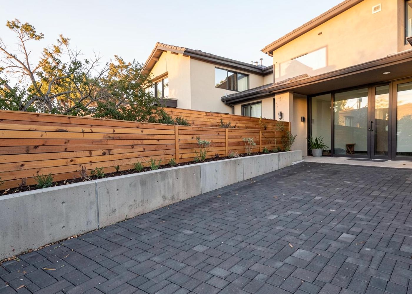 Paver driveway with concrete retaining wall and horizontal cedar fence